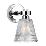 Introducing the Gunnislake 1 Light Wall Light - Polished Chrome, a wall-mounted lamp with a conical prismatic glass shade that features a textured grid-like pattern for casting a cozy warm glow. Its polished chrome base is shiny and round, showcasing a modern design that enhances its sleek aesthetic.
