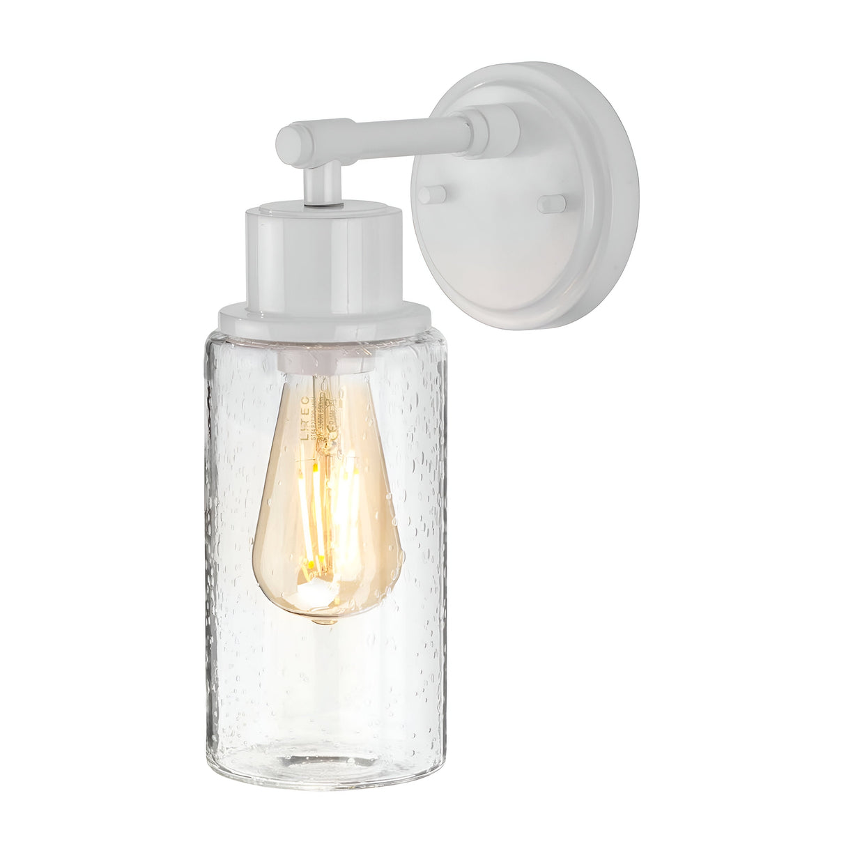 The Morvah 1 Light Outdoor Wall Light in white features a wall-mounted sconce with a clear, textured glass shade. It houses an LED Edison bulb that emits a warm glow, highlighting its minimalist and modern design. Ideal for outdoor spaces, it is IP44 rated, providing durability across various weather conditions.