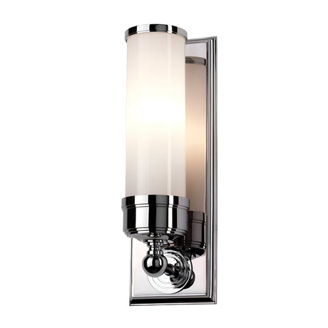 The Worcester 1 Light Wall Light in polished chrome features a cylindrical frosted glass shade that emits a soft, warm glow. With its sleek design, it embodies a modern yet transitional elegance, making it perfect for contemporary interiors.