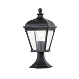 The Bayview 1 Light Medium Pedestal Lantern - Black is a vintage-style outdoor lighting fixture with a clear glass enclosure showcasing a visible light bulb, elegantly mounted on a decorative base. Its classical Georgian design brings timeless charm to any exterior space.