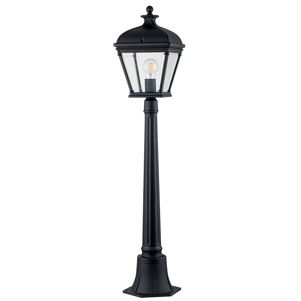 The Bayview 1 Light Medium Pillar Lantern - Black exudes elegance with its Georgian-inspired design, featuring a clear glass lantern and visible bulb that evoke a sense of timeless charm. Set against a plain white background, this lamp post captures the sophistication of classic outdoor lighting.