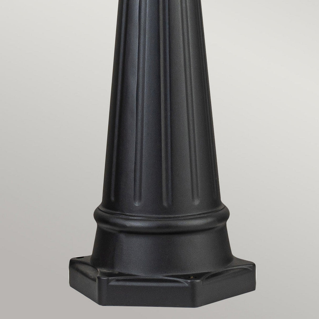 A timeless Bayview 1 Light Lamp Post in black, featuring a fluted cylindrical design and a wide hexagonal base, stands against a gray background, reminiscent of classic outdoor lighting styles.
