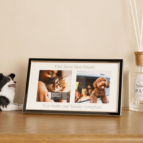 Black metal double photo frame with silver beaded edge and white mount reading Our furry best friend and You make our family complete, on a wooden sideboard beside a dog figurine.