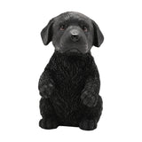 Black resin Labrador puppy figurine, 16cm, sitting up with both front paws raised and floppy ears, textured fur finish, shown on a plain white background.