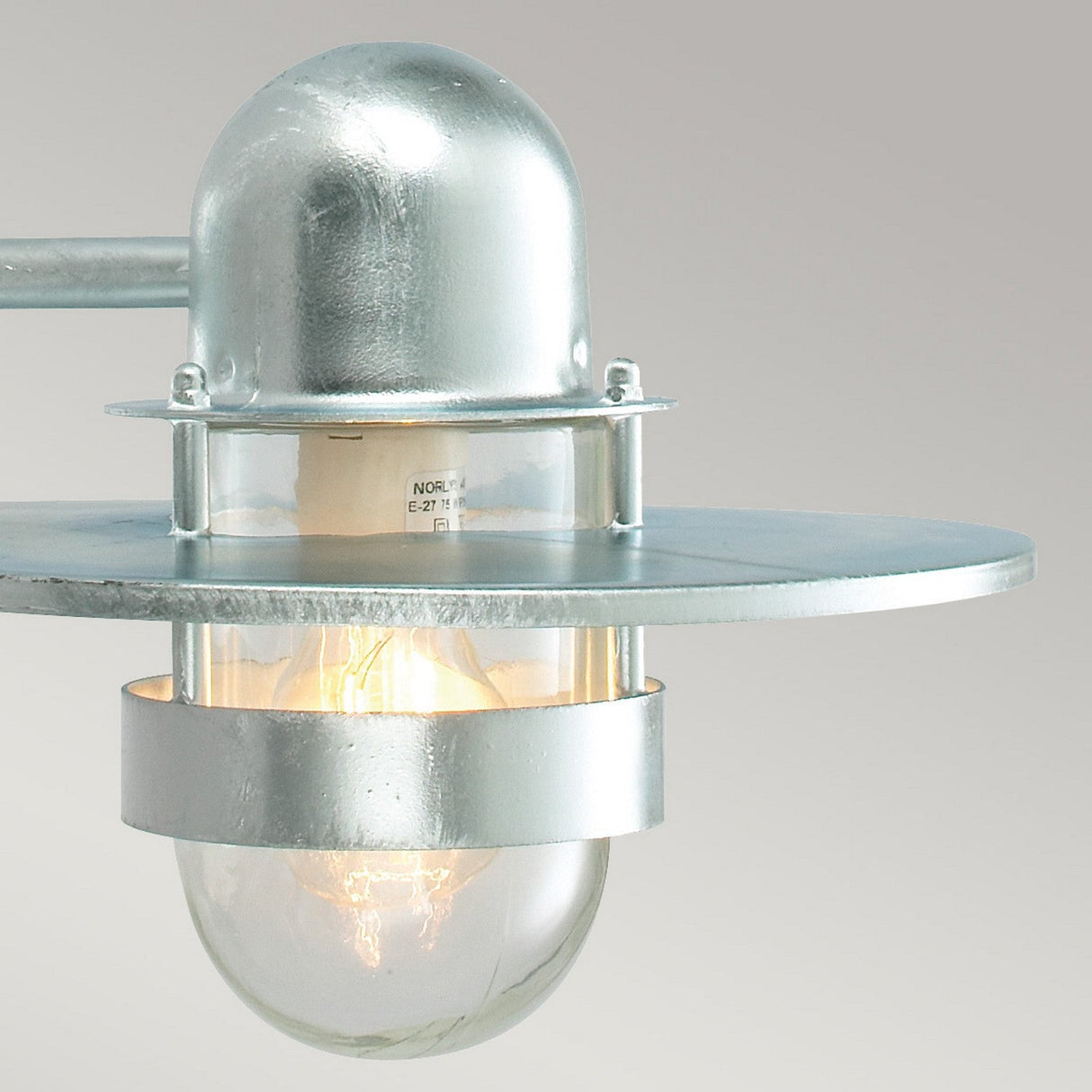 Here's a rephrased version of the sentence using the given product data:

Featuring a round glass bulb, the Bergen Outdoor 1 Light Wall Lantern - Silver boasts an industrial-style design with Art Deco flair. It has a domed top and flat circular base, providing a warm glow that's perfect for outdoor spaces thanks to its sturdy IP55 rating.