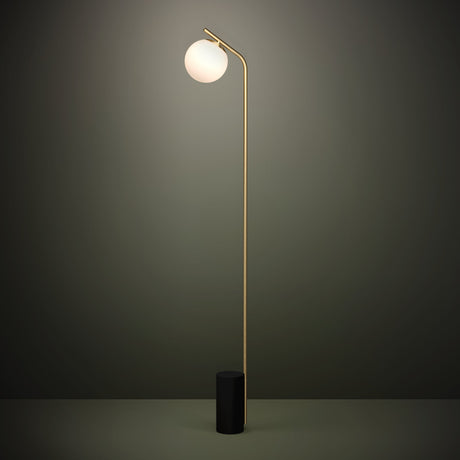 Betulia Floor Lamp in black and brass, with a slender steel stem curving over a white opal glass globe, set on a cylindrical black base against a dark background.