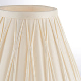 Close-up of the Bevdon 20cm tapered lamp shade in ivory silk, showing hand-stitched pinch pleats and a silk taped edge on a plain white background.