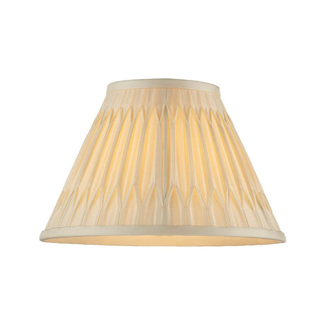 Endon Bevdon 25cm tapered lamp shade in ivory silk with hand-stitched double pinch pleats and box pleat detailing, shown illuminated on a white background.