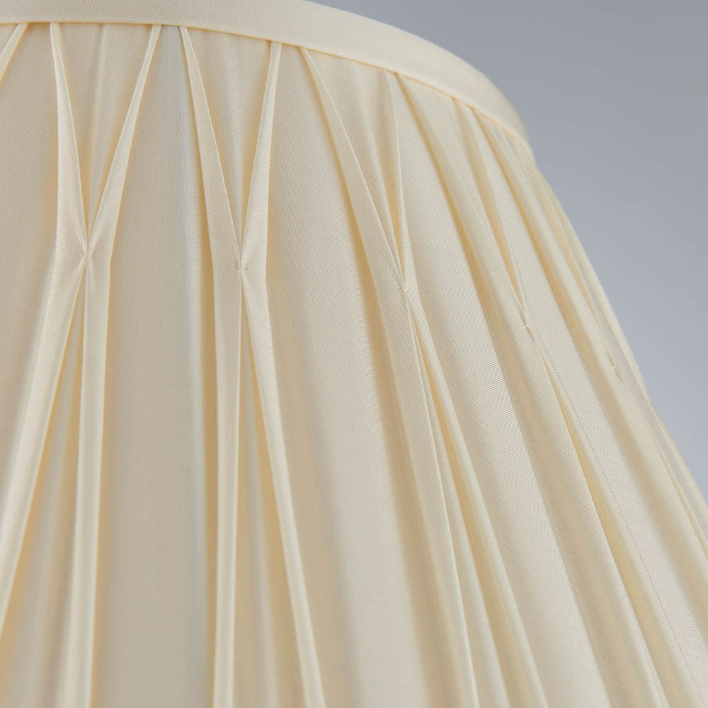 Close-up of the Bevdon 35cm tapered lamp shade in ivory silk, showing hand-stitched pinch pleats and box pleat detailing on a light background.