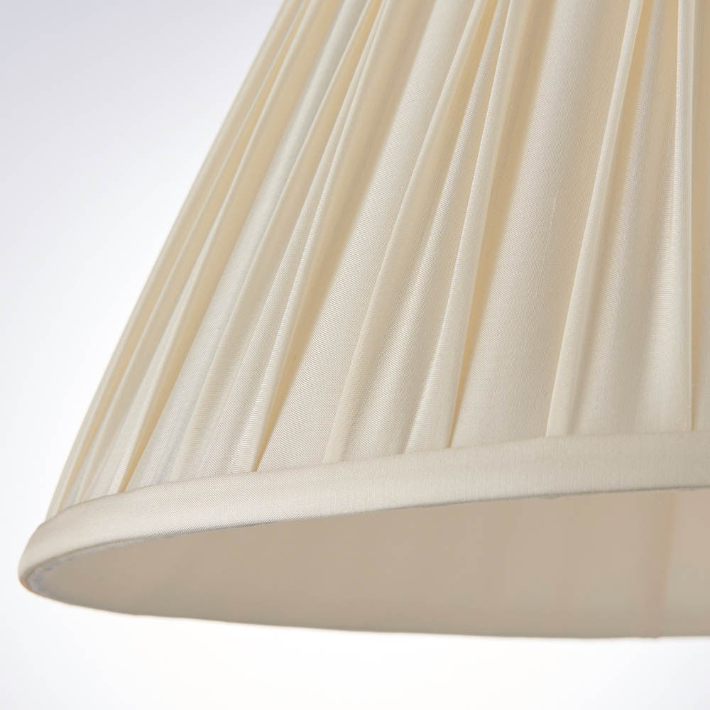 Close-up of the Bevdon 35cm tapered lamp shade in ivory silk, showing hand-stitched pinch pleats and a taped edge trim.