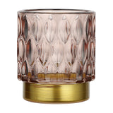 Bezamby glass tealight holder in dusky pink with raised almond-shaped facets, set on a gold-coloured metal base, shown against a plain white background.