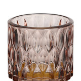 Bezamby glass tealight holder in dusky pink, close-up of the faceted almond-pattern sides with an amber-toned glass base, shown against a plain white background.
