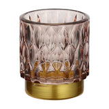 Bezamby glass tealight holder in dusky pink with raised almond-shaped facets and a gold-coloured metal base, shown on a plain white background.