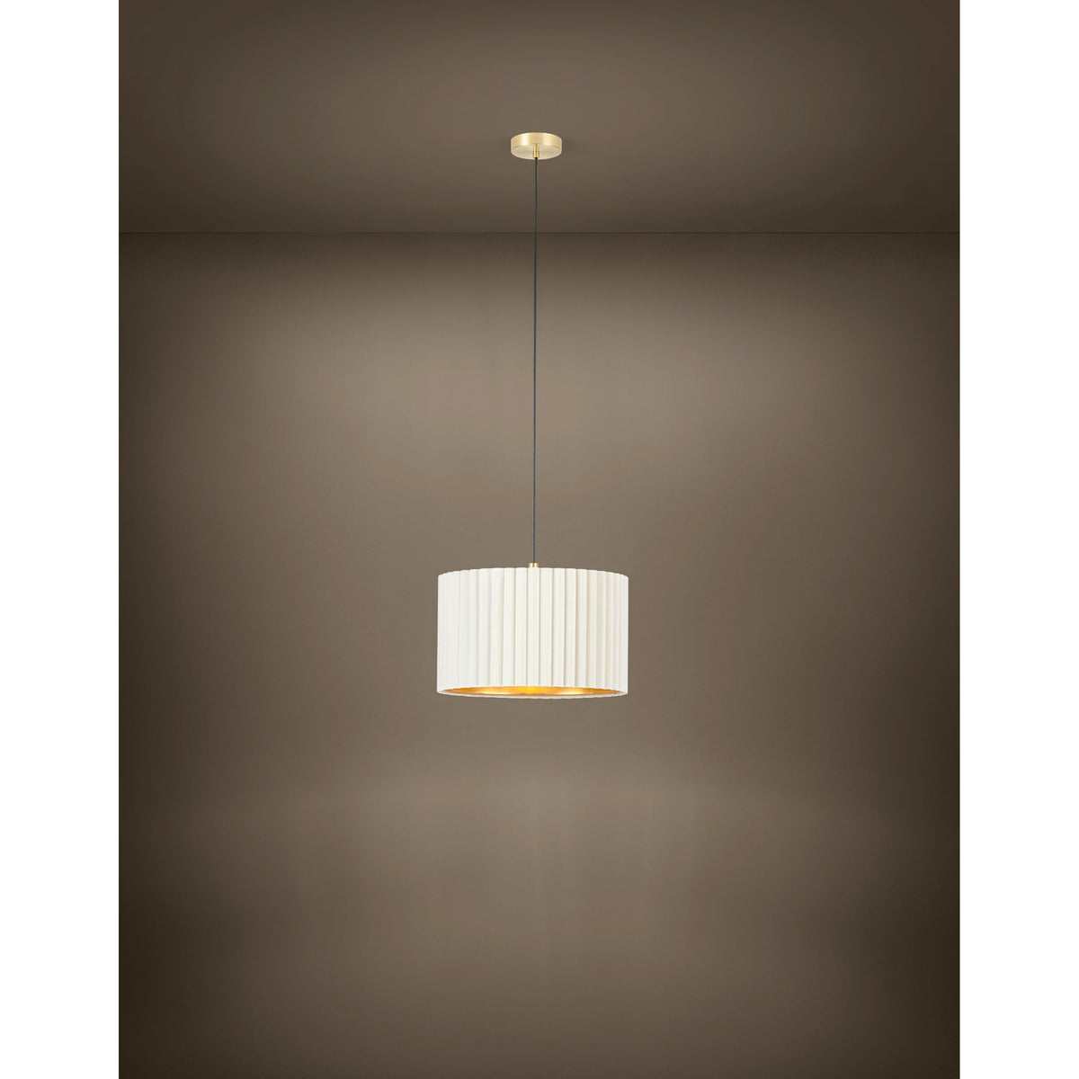 Birbenne Pendant Light in brushed brass with a pleated white velvet drum shade and gold interior, hung on a black cord from a round ceiling canopy against a plain brown background.