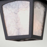 Here's a close-up of the York 1 Light Outdoor Ceiling Light in black, featuring a square design crafted from durable die-cast aluminum with frosted glass panels. The black metal frame softly emits warm light, and the textured glass adds a subtle pattern to the illuminated surfaces, enhancing its vintage aesthetic.