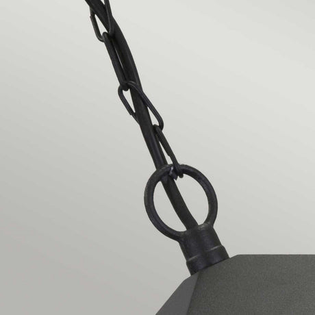 Close-up of the York 1 Light Outdoor Chain Light - Black, featuring a black chain and loop connected to its angular structure, evoking a vintage aesthetic against a plain light gray backdrop.