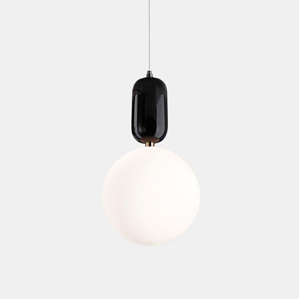 The Pallo Pendant Light - Black highlights a minimalist design with its glossy black fixture and spherical white bulb, all suspended from a slender cord, set against a plain gray backdrop to exude European elegance.