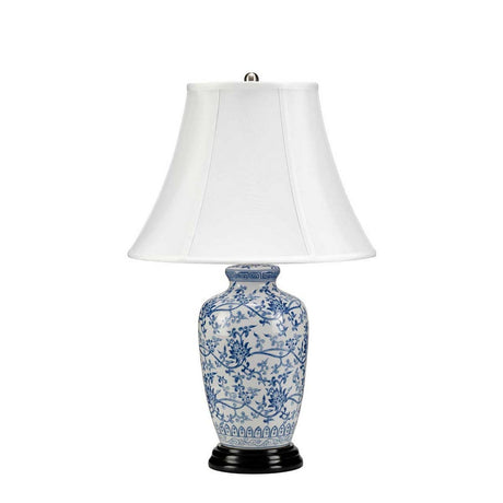 Explore the exquisite Blue Ginger Jar Table Lamp - Blue & White, a remarkable piece of Chinese craftsmanship. This decorative table lamp boasts a white pleated lampshade above a blue and white base adorned with intricate floral and vine patterns, all gracefully positioned on a dark, round pedestal.