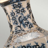 Close-up of a ceramic vase with intricate blue floral patterns and a bird design on a cream background, showcasing traditional Chinese craftsmanship. The vase features a crackled glaze texture, reminiscent of the elegance found in the Blue Hex Table Lamp - Blue & White.