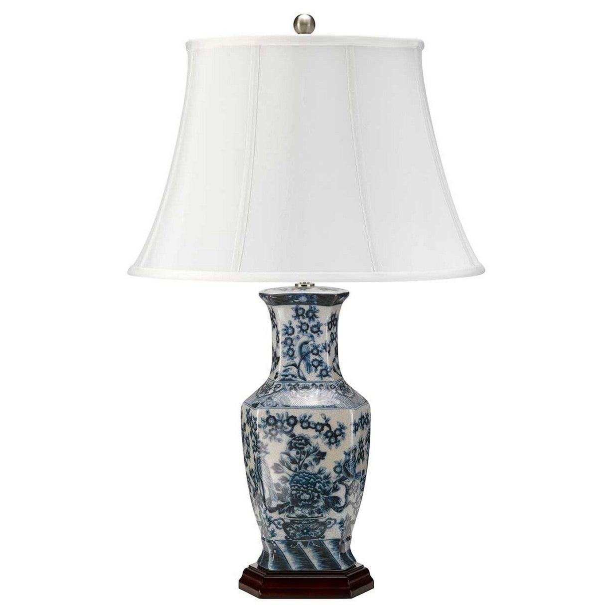 Introducing the Blue Hex Table Lamp - Blue & White, featuring a white lampshade and a decorative porcelain base embellished with intricate blue floral patterns that reflect traditional Chinese artistry. The sophisticated base is elegantly positioned on a small wooden platform.