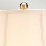A close-up of the beige lampshade from the Blue Traditional Table Lamp - Blue & White, featuring a brushed metal finial at the top and set against a light gray background, evokes cultural charm reminiscent of Chinese porcelain artistry.
