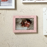 Pink MDF photo frame reading "Our little princess" and "LOVE YOU SO MUCH", with moon, star and cloud details, mounted on a textured wall holding a baby's photo.