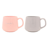 Set of 2 porcelain mugs, "mummy" in pink and "daddy" in grey, with silver lettering, stars and crescent moon detail, rounded handles, on a plain white background.