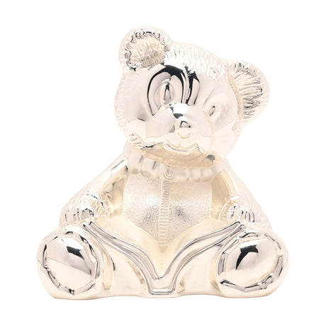 Silverplated sitting teddy bear money box with textured fur head and ears, ribbed collar, and open book across its lap, shown on a plain white background.