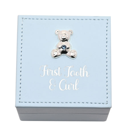 Square light blue plastic keepsake box with stitched border, silver-tone teddy bear with blue gem, and "First Tooth & Curl" foiled in silver script, on a plain background.