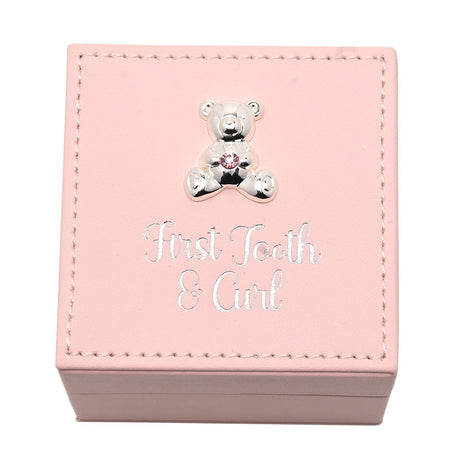 Square pink plastic keepsake box with stitched edging, a silver teddy bear with pink gem detail, and silver "First Tooth & Curl" script on the lid, shown on a white background.