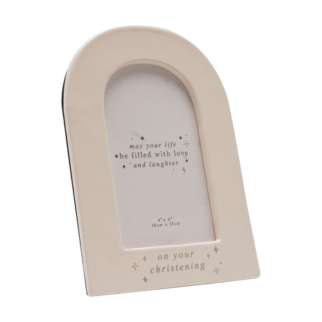 Cream ceramic arch-shaped photo frame for a 6 x 4in print, with "on your christening" in silver foil and star details along the base, shown on a plain white background.