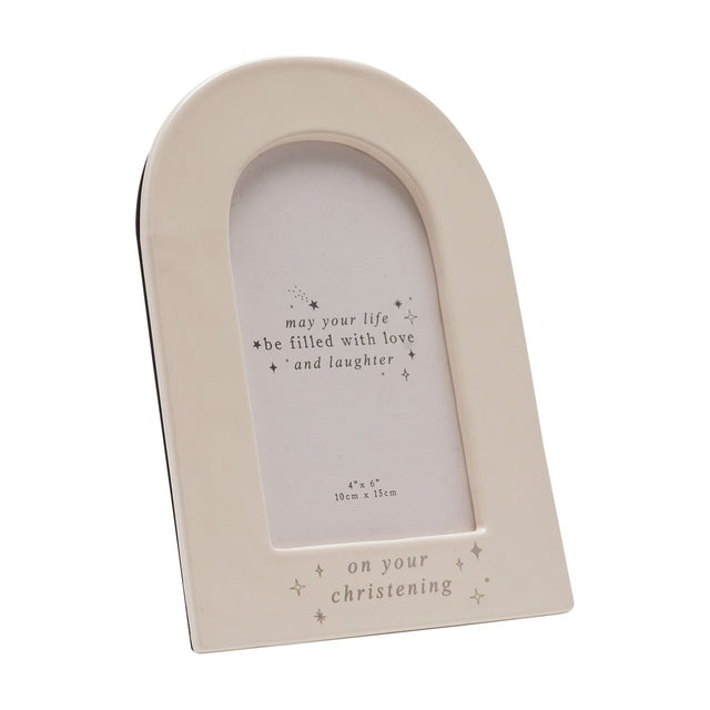 Cream ceramic arch-shaped photo frame for a 6 x 4in print, with "on your christening" in silver foil and star details along the base, shown on a plain white background.