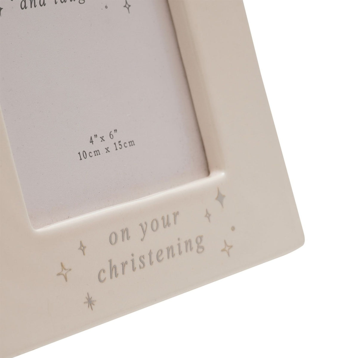Close-up of cream ceramic christening photo frame corner, showing "on your christening" text with silver stars and 4"x6" print size marking.