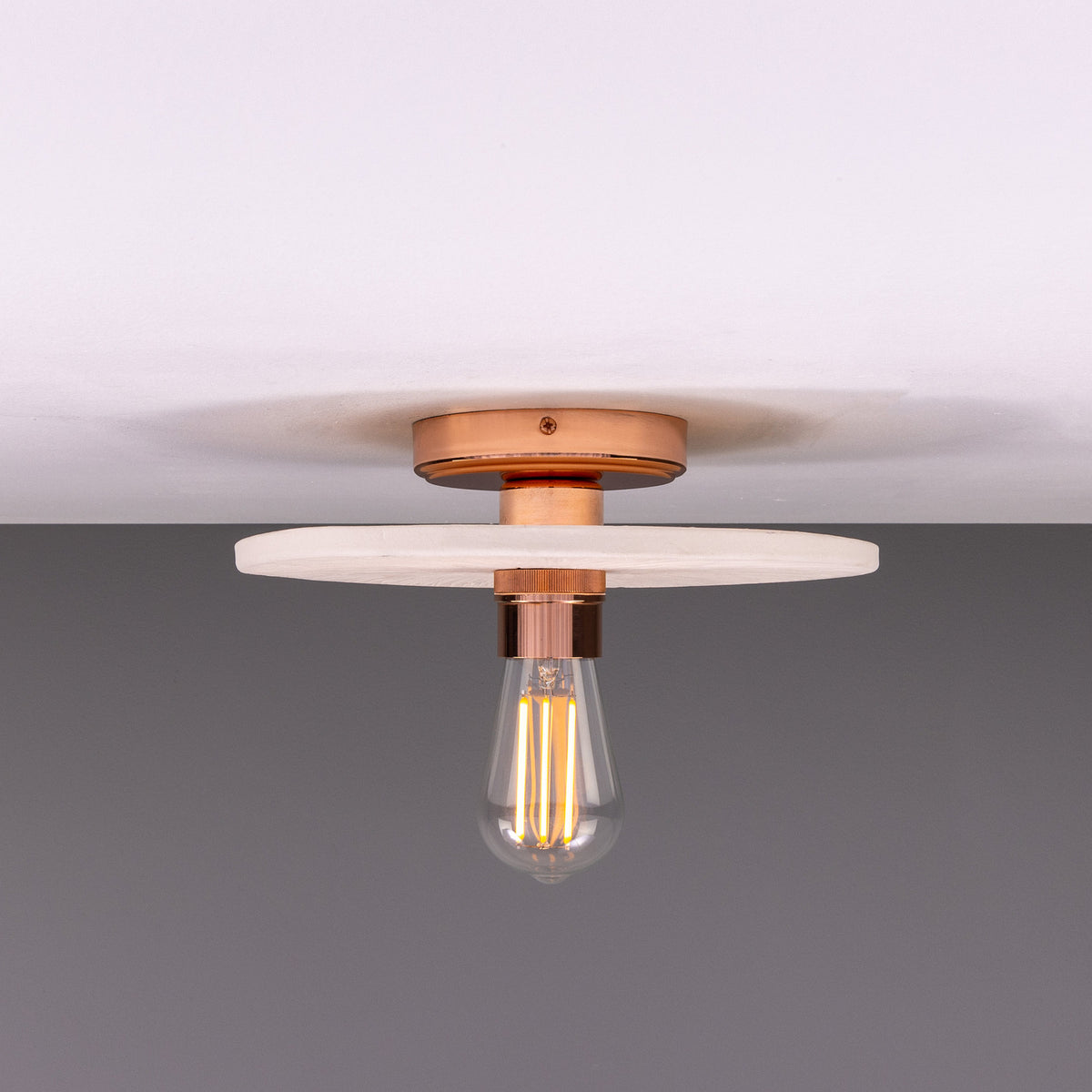 Bog Oak ceramic ceiling light with a flat round Matt White Striped disc and copper-finish fitting, holding a single exposed bulb against a plain background.