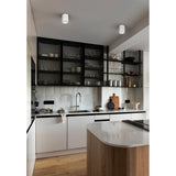 Bohoyo LED Downlight in white, a compact surface-mounted aluminium cylinder shown on a kitchen ceiling above a kitchen island with black-framed glass cabinets.