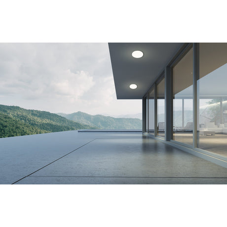 Bosmine round white LED flush ceiling lights, 31cm, mounted under a modern overhang on a terrace overlooking mountains and glass-walled interior.
