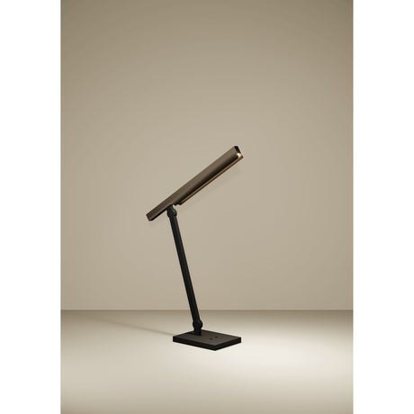 Bostelo LED table lamp with a slim angled bronze bar head on a black steel jointed stem and rectangular base, shown on a plain neutral background.
