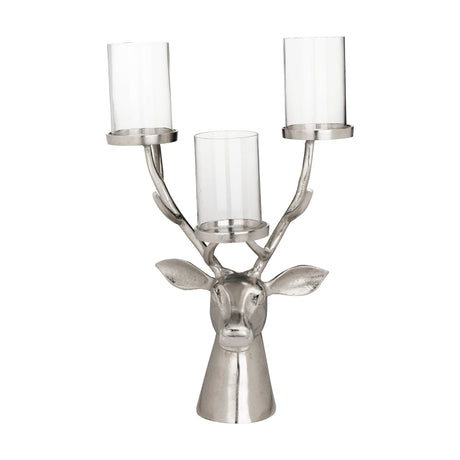 Braawe Candle Holder in nickel-finish aluminium, shaped as a stag's head with antlers holding three clear glass hurricane cylinders on round metal dishes, set against a plain white background.