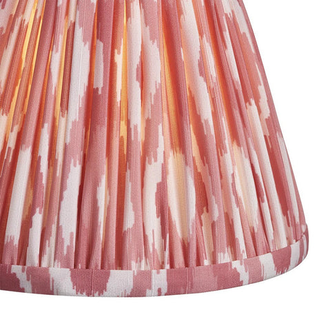 Close-up of Endon Brenwell 16cm tapered lamp shade in coral pink and white ikat print on pleated faux silk with taped edge detailing.