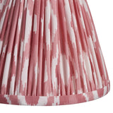 Close-up of Endon Brenwell 16cm tapered lamp shade in coral pink, showing pleated faux silk with ikat print and taped edge trim.