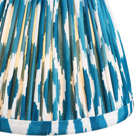 Close-up of Endon Brenwell 16cm tapered lamp shade in marlin blue, showing pleated faux silk with blue and white ikat print and taped edge trim.