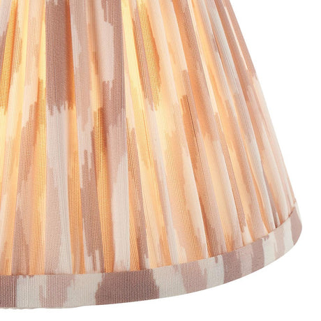 Close-up of the Endon Brenwell 16cm tapered lamp shade in neutral, showing pleated faux silk with an ikat print in soft pink and cream tones.