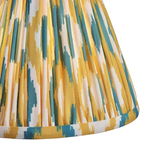 Close-up of Endon Brenwell 16cm tapered lamp shade in pleated faux silk with a yellow and jade ikat pattern and taped edge trim.