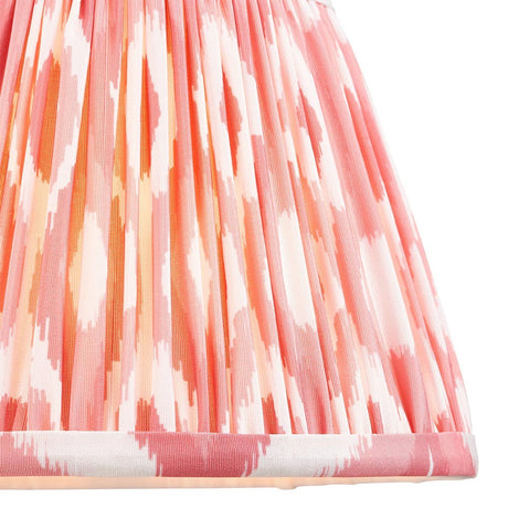 Close-up of Endon Brenwell 20cm tapered lamp shade in coral pink and white ikat print on pleated faux silk with taped edge detailing.