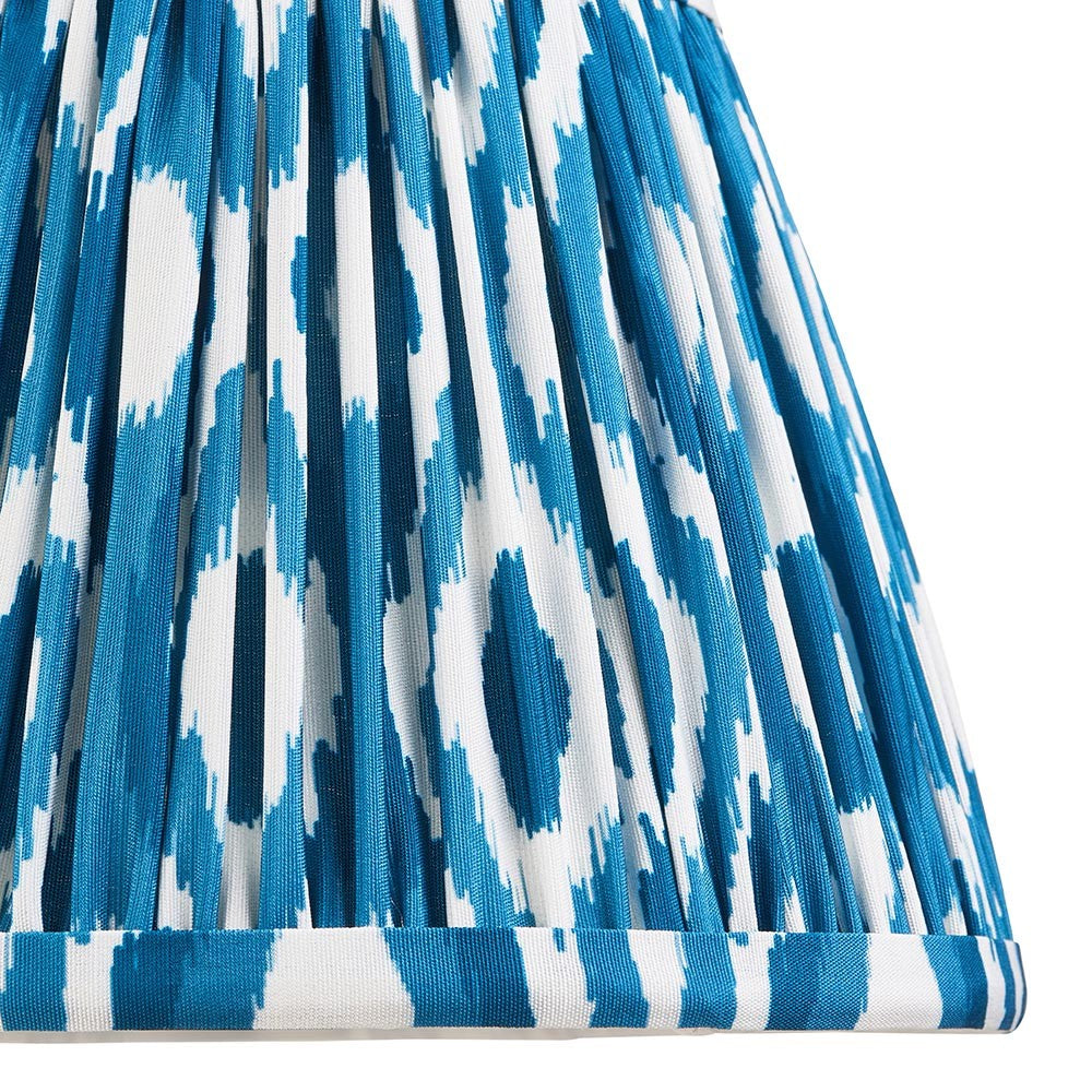 Close-up of Endon Brenwell 20cm tapered lamp shade in marlin blue and white ikat print on pleated faux silk with taped edge detailing.