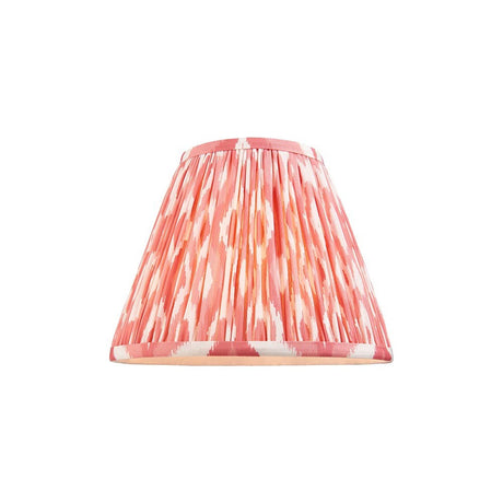 Endon Brenwell 25cm tapered lamp shade in pleated faux silk with a coral pink and white ikat print and taped edges, on a plain white background.