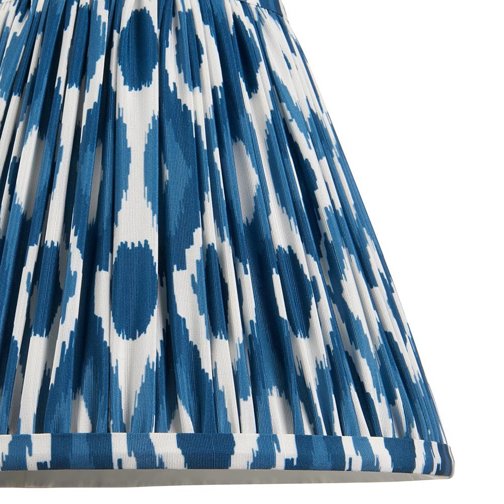 Close-up of Endon Brenwell 25cm tapered lamp shade in marlin blue and white, showing pleated faux silk with ikat pattern and taped edge detail.