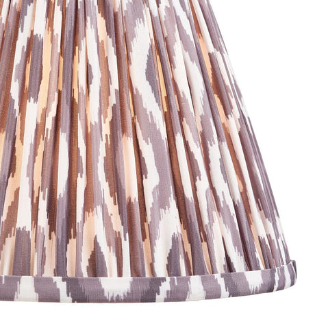 Close-up of Endon Brenwell 25cm tapered lamp shade in pearl grey, showing gathered pleated faux silk with an ikat pattern in grey, cream and warm tones.