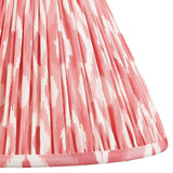 Close-up of Endon Brenwell 30cm tapered lamp shade in coral pink and white ikat print on gathered pleated faux silk with taped edge trim.