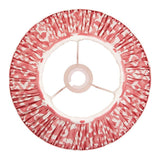 Endon Brenwell 30cm tapered lamp shade in coral pink and white ikat print faux silk, pleated with taped edges and gimbal fitting, top view on white.